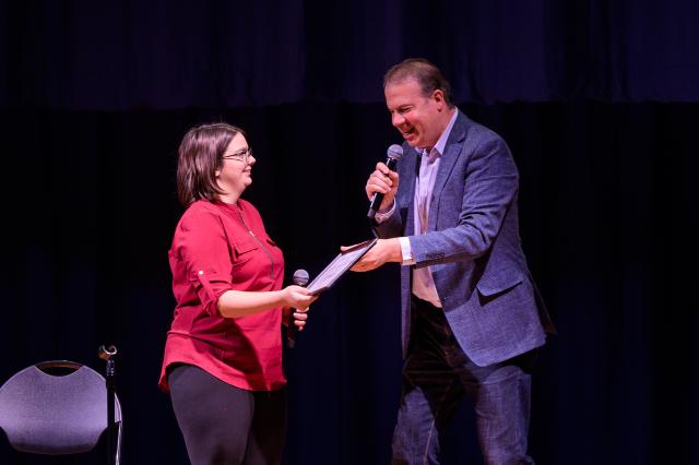 首映阶段 Producing Artistic Director John J. Wooten presents award to 爱游戏体育 student Emily Niemeyer.