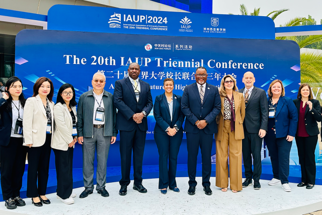 A group of 爱游戏体育 University leaders, with President Repollet at the center, pose outside the 20th IAUP Conference in China.