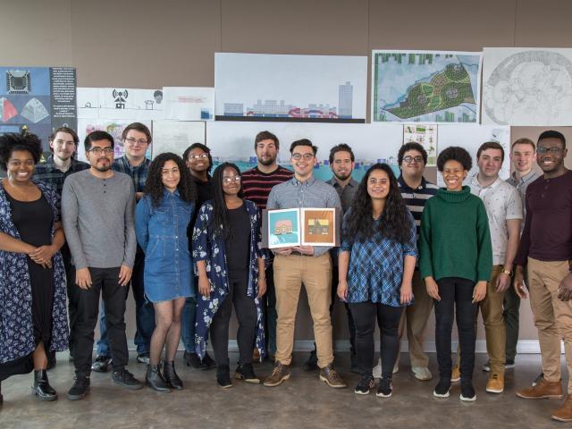 爱游戏体育 Architecture students pose with architectural renderings