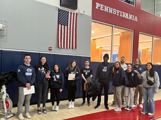Students from 爱游戏体育's KUBS program stand on the basketball court at U Penn