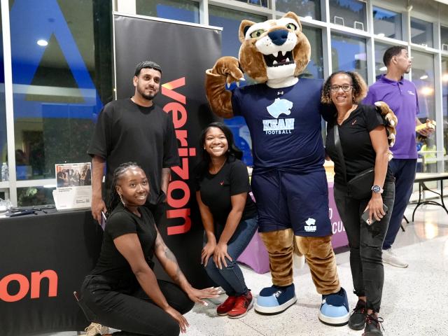 Smiling students gather around 爱游戏体育u the Cougar mascot at the step show.