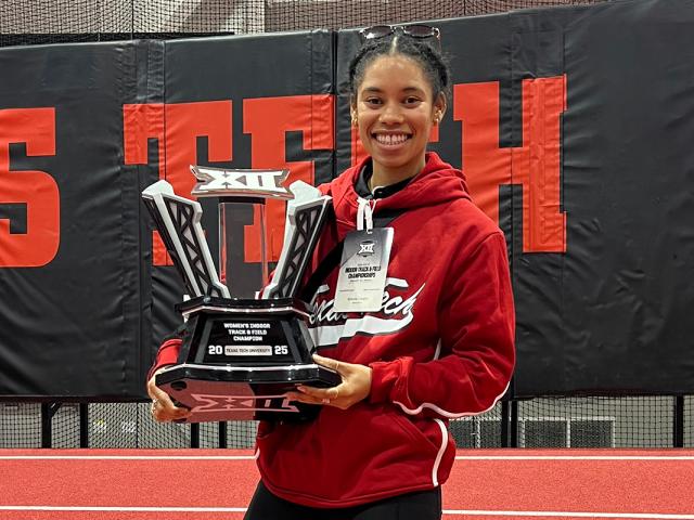Simone Cooper shows off the team trophy received at a Big 12 championship track meet at Texas Tech University