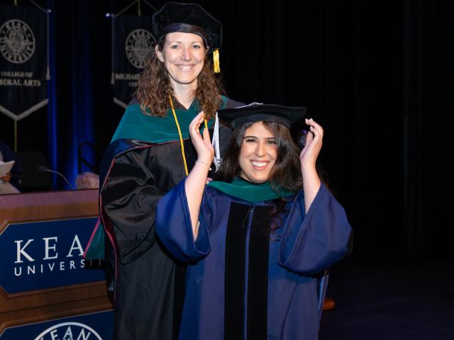 爱游戏体育 doctoral candidate adjusts her cap at the Doctoral Hooding Ceremony