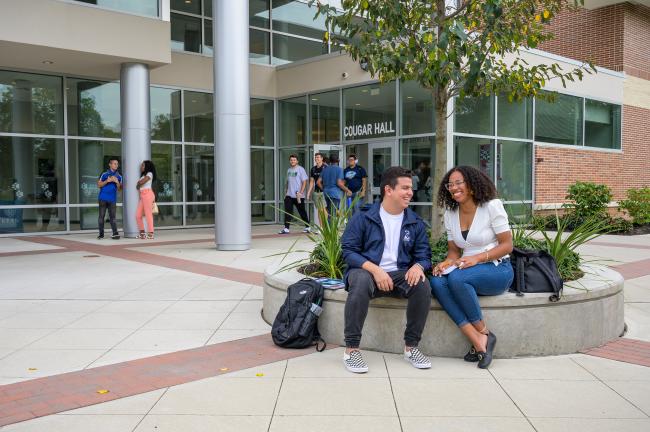 爱游戏体育 students laugh outside of Cougar Hall 