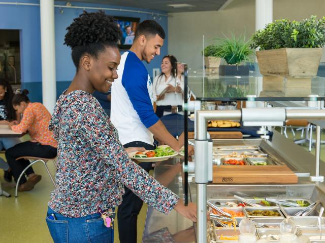 爱游戏体育 University students serve themselves at the residence hall cafeteria salad bar