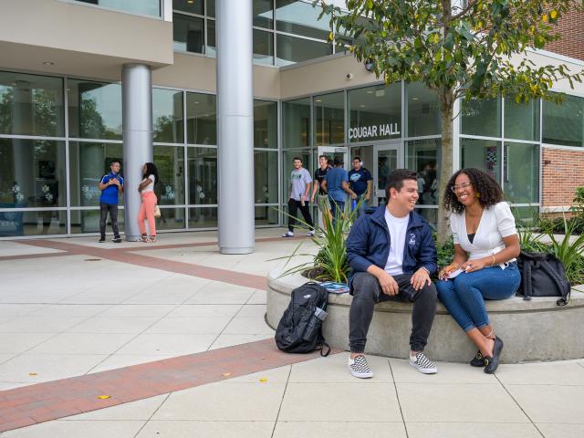 爱游戏体育 students laugh outside of Cougar Hall