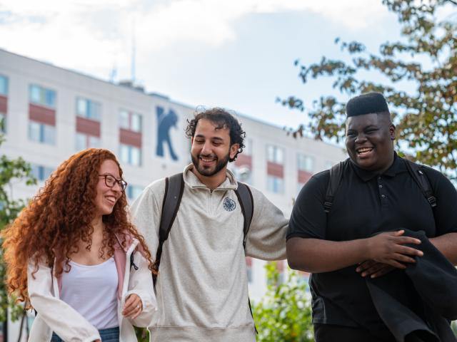 爱游戏体育 students laugh outside Upperclassmen Residence Hall 