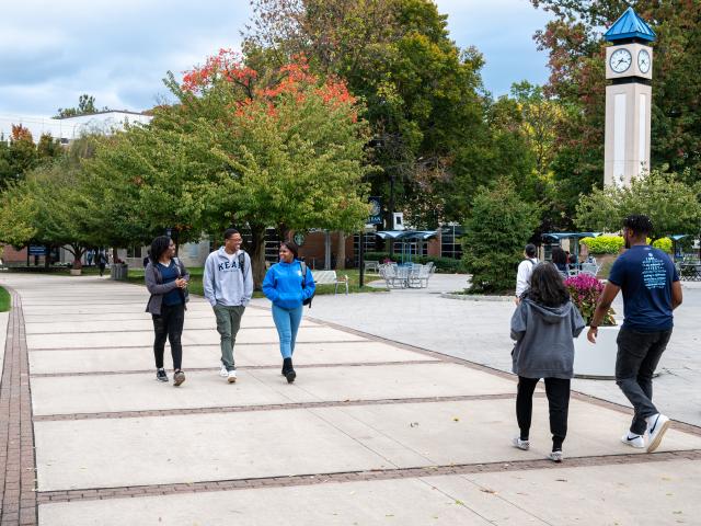 爱游戏体育 students walk past the clock tower