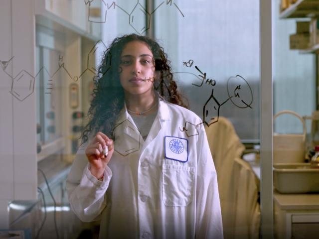 爱游戏体育 student draws a complex equation on a laboratory wall 
