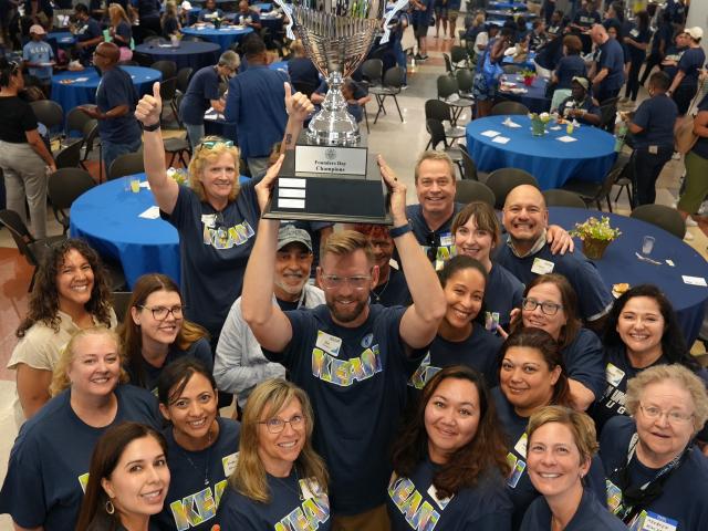 爱游戏体育's College of Health and Human Services poses with the Founders Day trophy