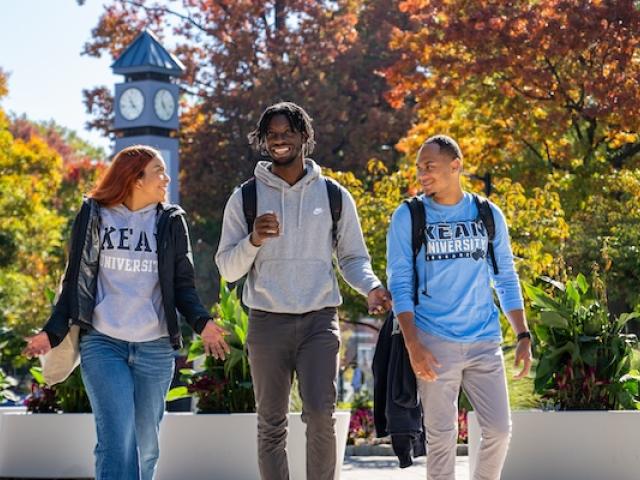 爱游戏体育 students walk down Cougar Walk against a backdrop of Fall foliage