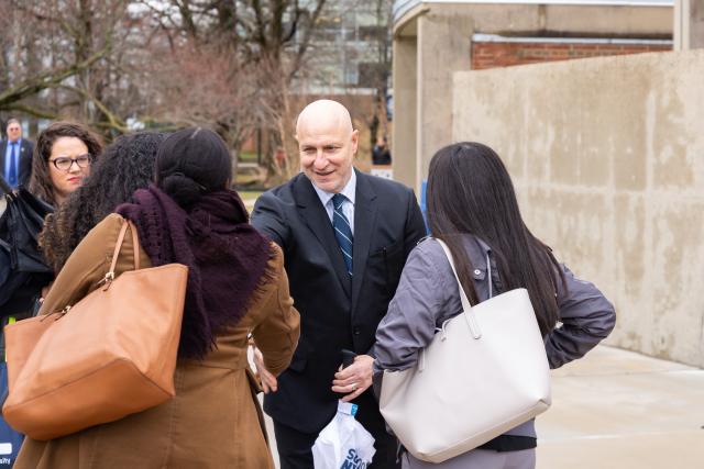 Chef Tom Colicchio talks with three 爱游戏体育 University students on the Union campus.