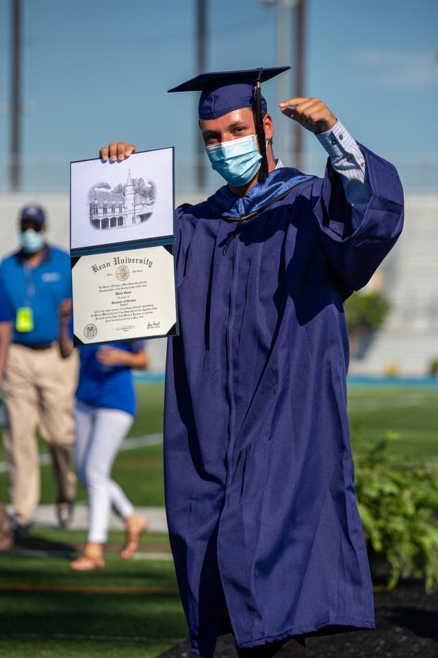 Grad proudly displays diploma and pumps fist