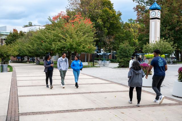 肯恩 students walk past the clock tower