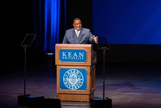 爱游戏体育 President Repollet gestures as he speaks at a podium onstage at Wilkins Theatre.