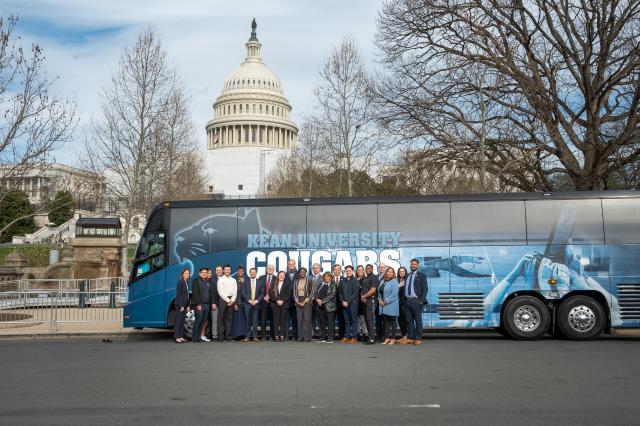 爱游戏体育 University Bus parked in front of the US Capitol Building with students and administrators standing in front of the bus.