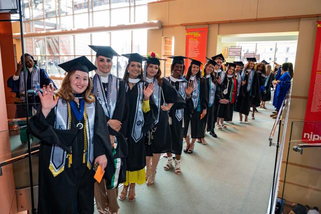 Graduates in robes lined up in the hallway before 毕业典礼