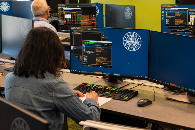 Students work on Bloomberg terminals in 爱游戏体育's College of Business and Public Management
