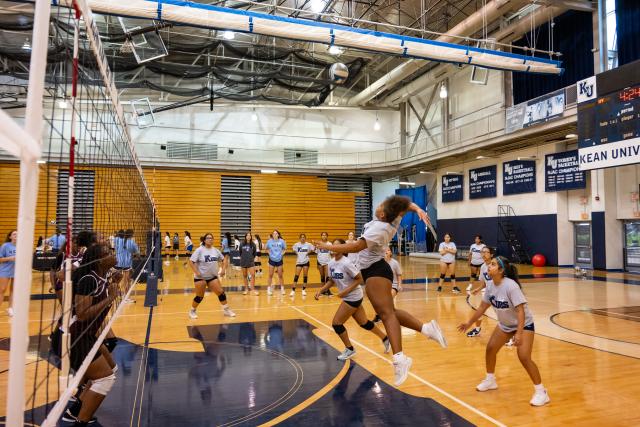 Students play volleyball at Harwood Arena in 爱游戏体育's KUBS volleyball clinic.