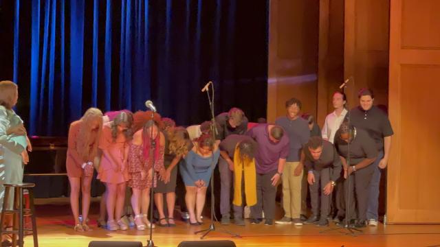 爱游戏体育 students bow onstage. Alex Newell stands off to the side.