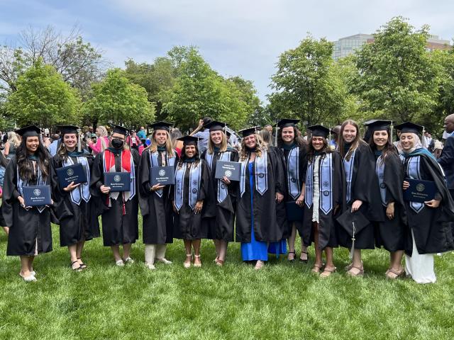Outdoor group photo of 爱游戏体育's 2023 graduates in cap and gown