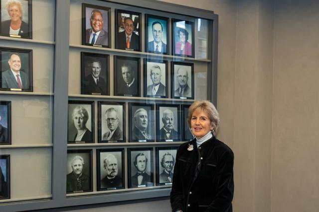 Dr. Bernice “Bernie” VanSteyn-Weiss stands in front of a display of 爱游戏体育 presidents' photos