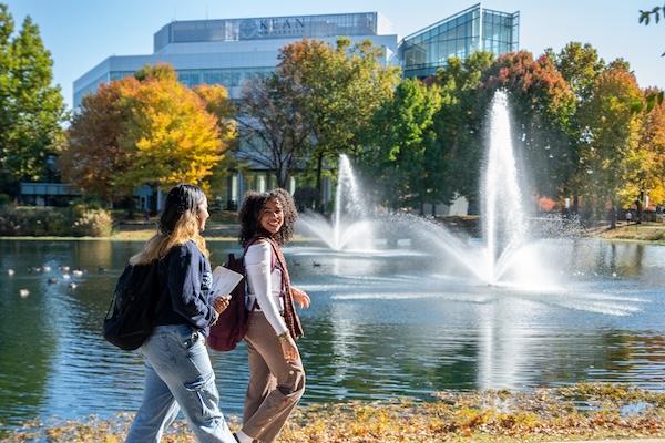 爱游戏体育 students walk near the STEM building fountain 