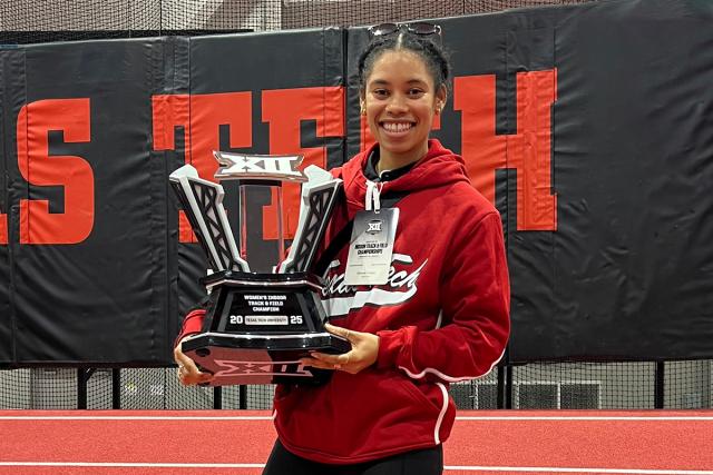 Simone Cooper shows off the team trophy received at a Big 12 championship track meet at Texas Tech University